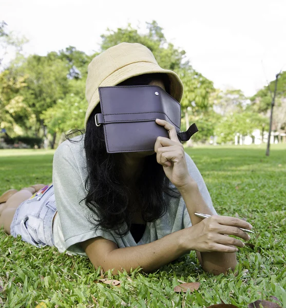Vrouw tot vaststelling van op gras en denken in park — Stockfoto