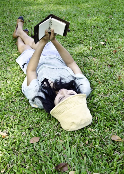 Jovem mulher lendo um livro no parque — Fotografia de Stock