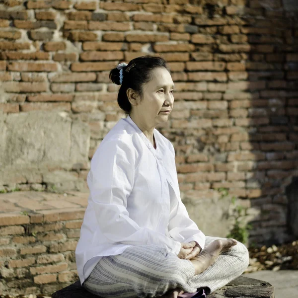 Aziatische vrouw mediteren in oude boeddhistische tempel — Stockfoto