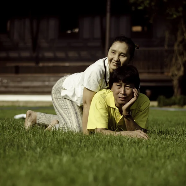 Casal deitado no chão no parque relaxante — Fotografia de Stock