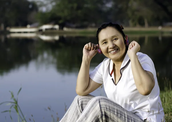 Vacker asiatisk kvinna lyssnar musik i hörlurar — Stockfoto