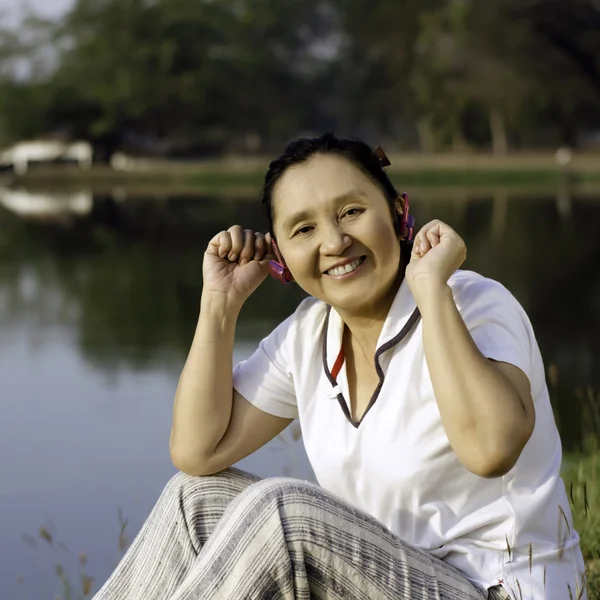 Beautiful asian woman listening music in headphones — Stock Photo, Image