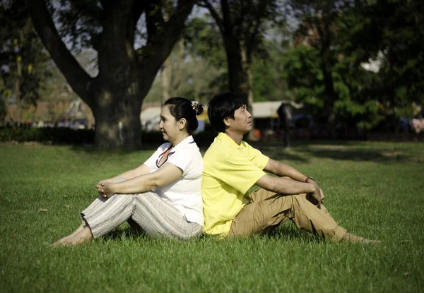 Ritratto di bella coppia seduta a terra nel parco — Foto Stock