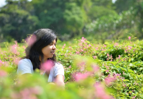 Young woman sitting in green rural field — Stock Photo, Image