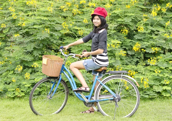 Bella giovane donna con bicicletta in un parco sorridente — Foto Stock