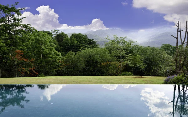 Wolkenspiegelungen am Infinity-Pool mit schöner Landschaft — Stockfoto