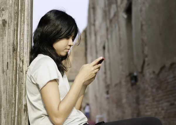 Mladá žena píše zprávu na mobilní telefon — Stock fotografie