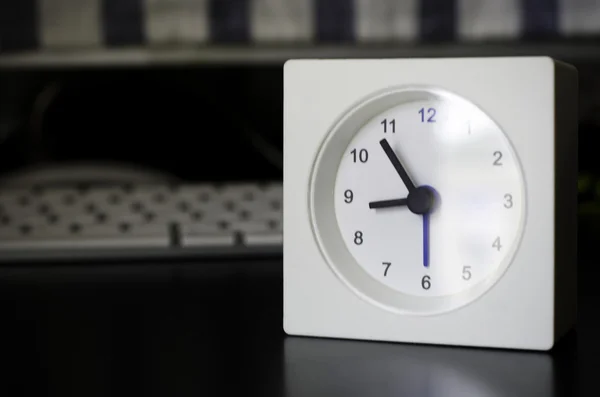 Horloge blanche, sur la table d'affaires dans le bureau — Photo
