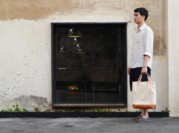 Uomo con borsa di tela su sfondo grunge cemento — Foto Stock