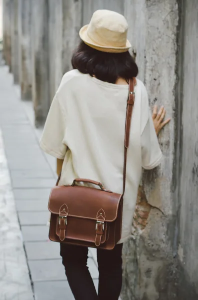 Девушка из моды с кожаной сумкой в переулке — стоковое фото
