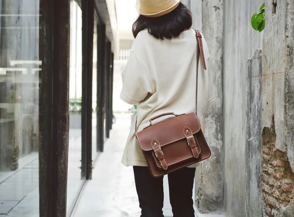 Fashion girl with leather bag at concrete alleyway — Stock Photo, Image