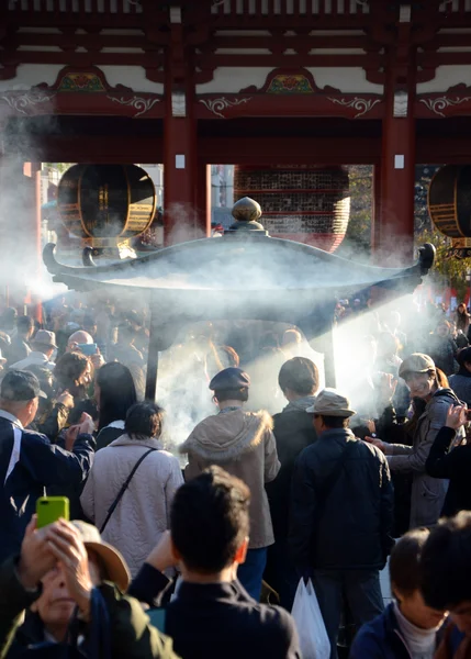 TOKYO, JAPAN - NOV 21: Buddhists gather around a fire to light incense and pray at Sensoji Temple — Stock Photo, Image