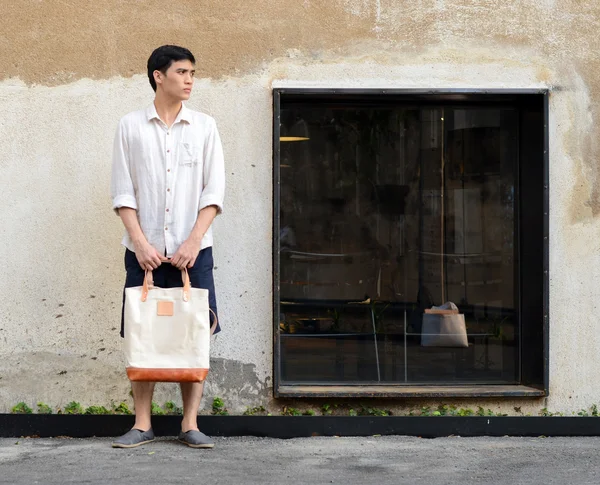 Homme avec sac en toile sur fond de béton grunge — Photo