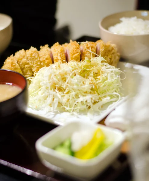 Gebakken gepaneerd varkensvlees geserveerd met gestoomde rijst en soep. — Stockfoto