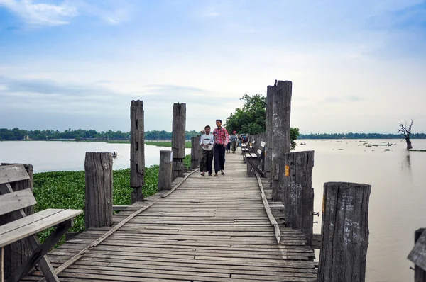 Amarapura, burma, oktober 9,2013: oidentifierade människor bär longitu, burmesiska traditionella kläder i u bein bridge — Stockfoto