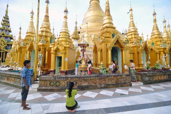 YANGON, MYANMAR - 11 de octubre: Peregrinos no identificados en el sendero alrededor de la pagoda dorada de Shwedagon —  Fotos de Stock