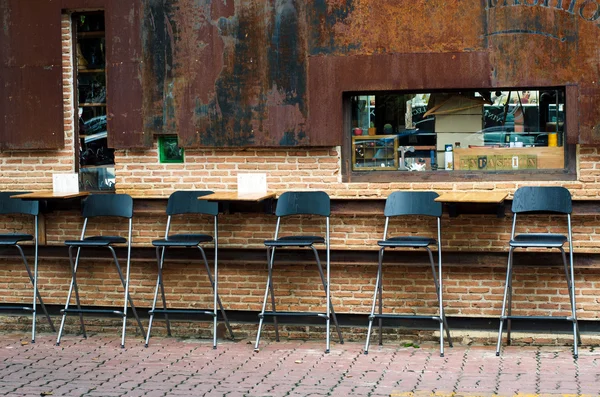 Cadeiras de café contra parede de tijolo — Fotografia de Stock