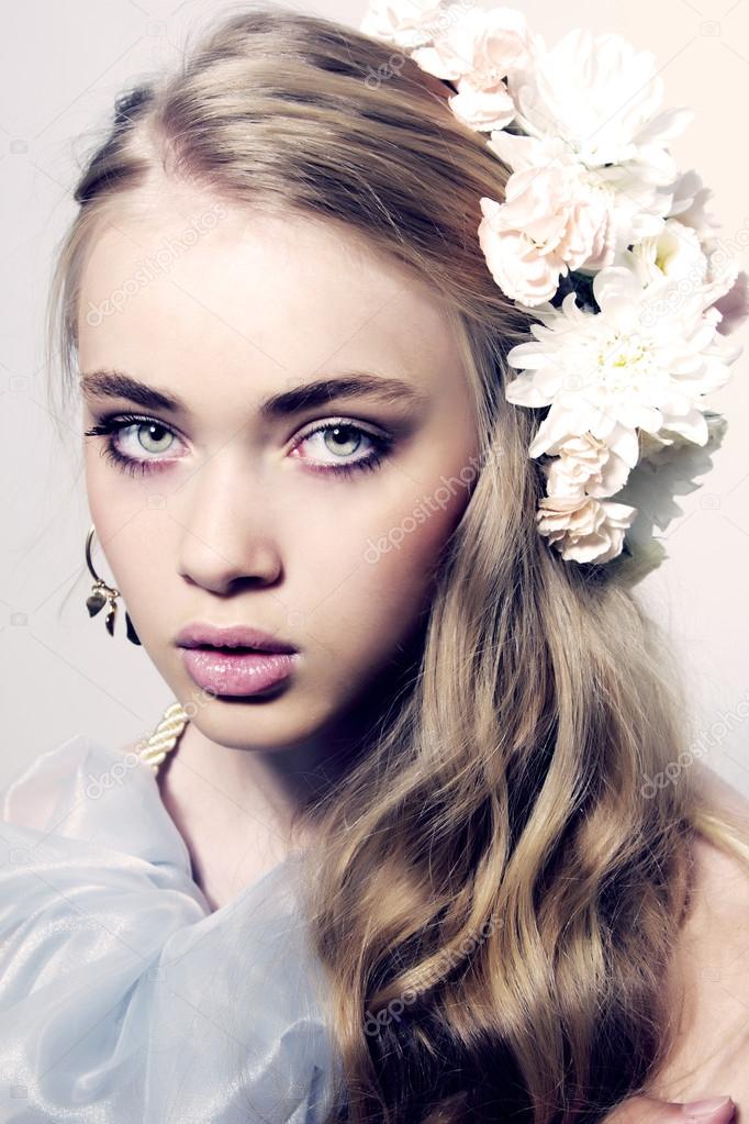 Closeup fashion color portrait of young model with flowers and j