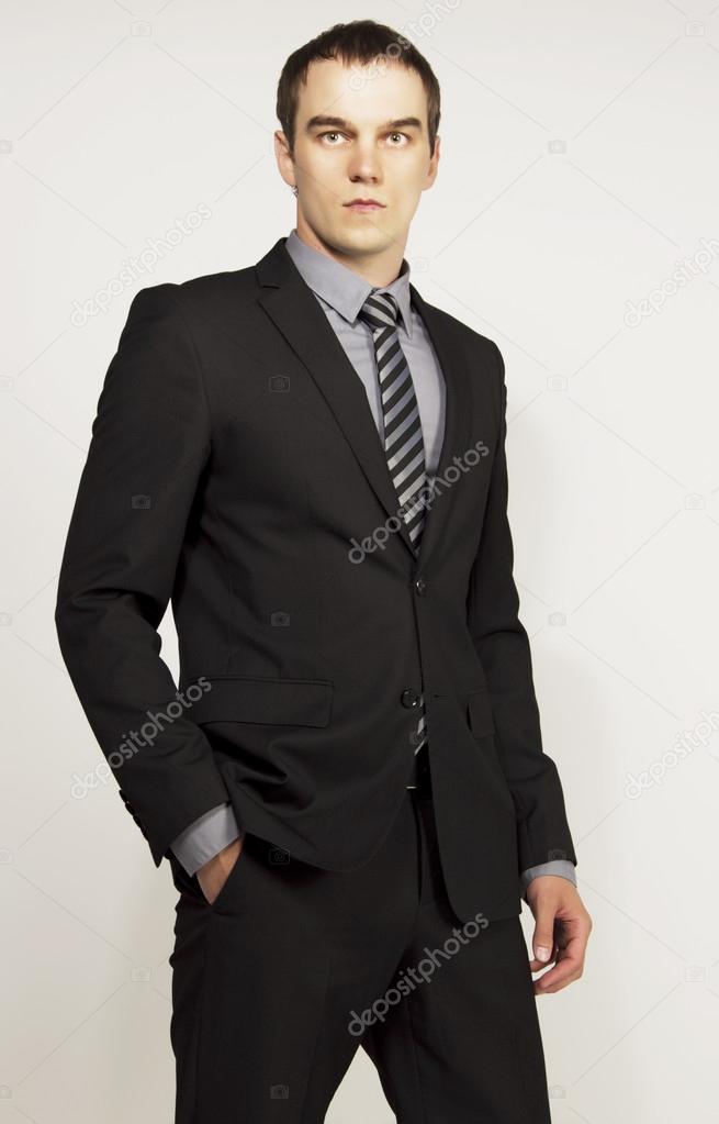 Young attractive business man in costume expessing strong emotio