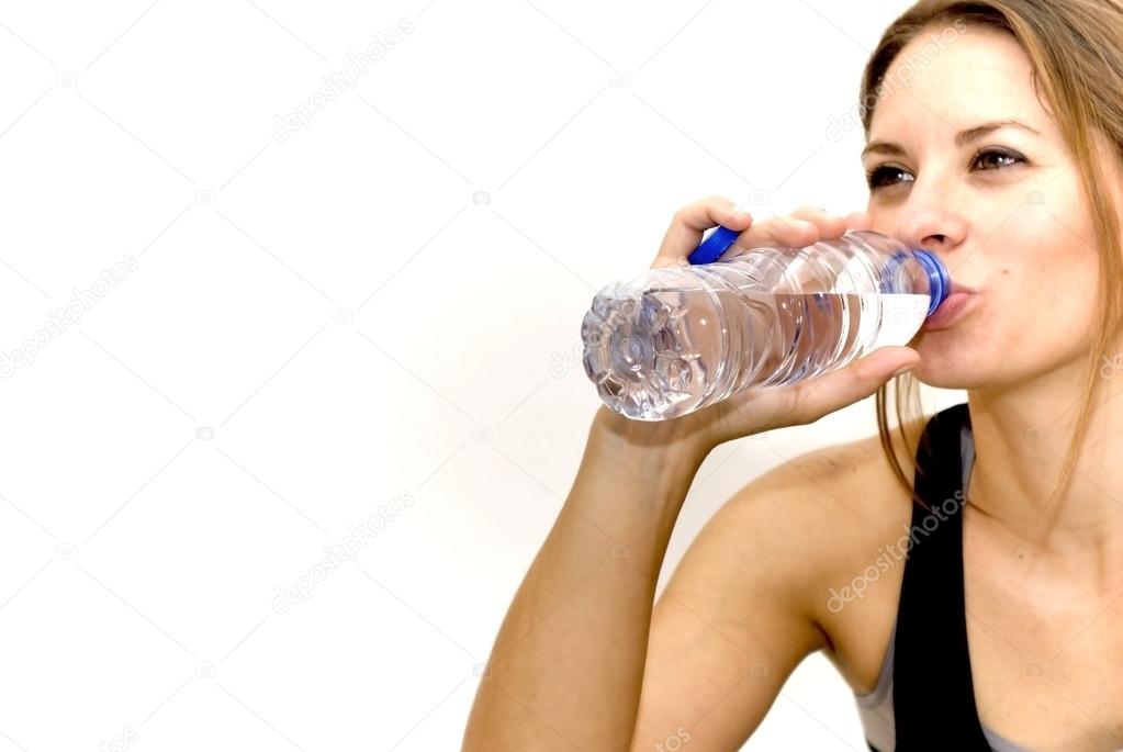 Beautiful woman drinking water after playing sports