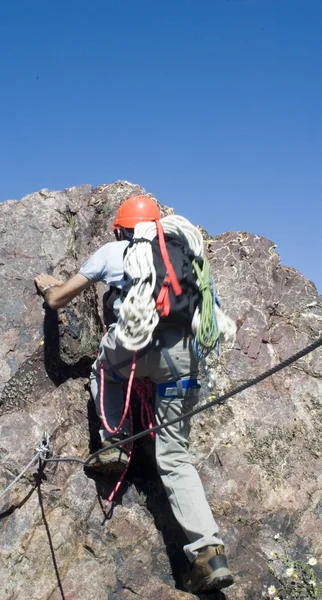 Climber climbing a vertical wall of a mountain — Stock Photo, Image