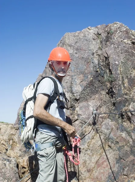 Climber climbing a vertical wall of a mountain — Stock Photo, Image