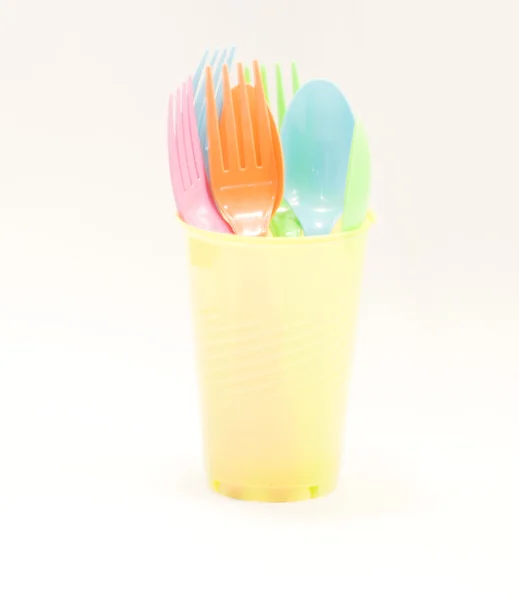 Plastic tableware consisting of spoon, fork and cups — Stock Photo, Image