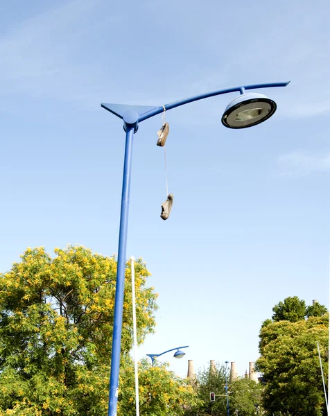 Old shoes hanging from their laces — Stock Photo, Image