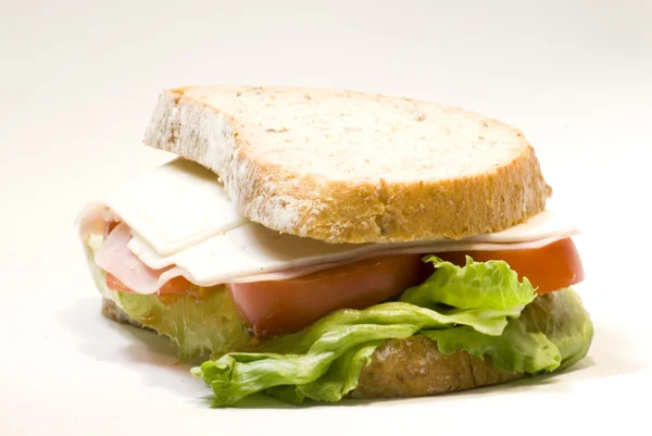 Сэндвич с сыром, ветчиной, помидорами и салатом — стоковое фото