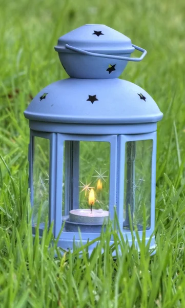 Blue Lantern, with burning candle inside, on green grass — Stock Photo, Image