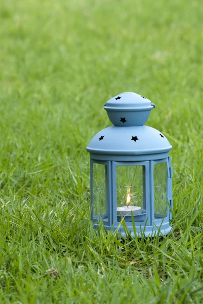 蓝色的灯笼，用燃烧的蜡烛，在绿色草地上 — 图库照片