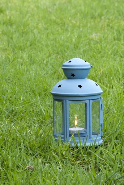 Lanterna Blu, con candela accesa dentro, su erba verde — Foto Stock