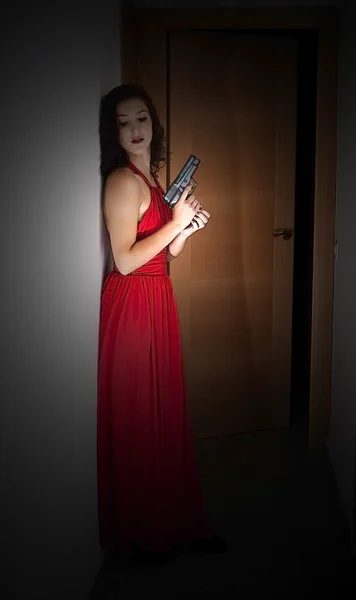 赤いドレスと銃を持つ美しい女性 — ストック写真