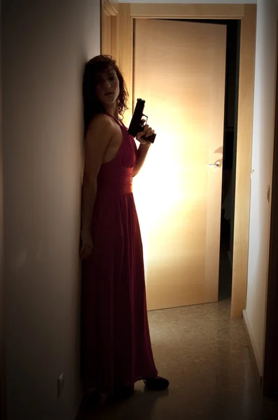 Hermosa mujer con un vestido rojo y un arma —  Fotos de Stock
