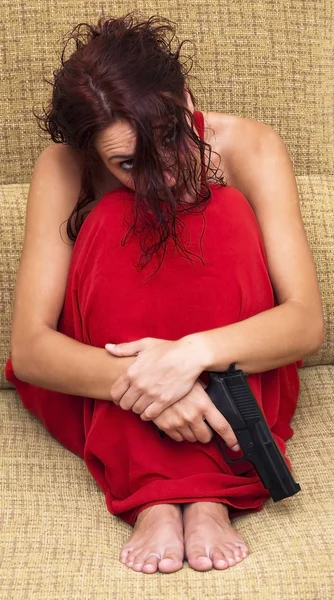 Hermosa mujer con un vestido rojo y un arma — Foto de Stock