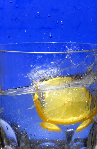 Limón cayendo en el agua clara — Foto de Stock