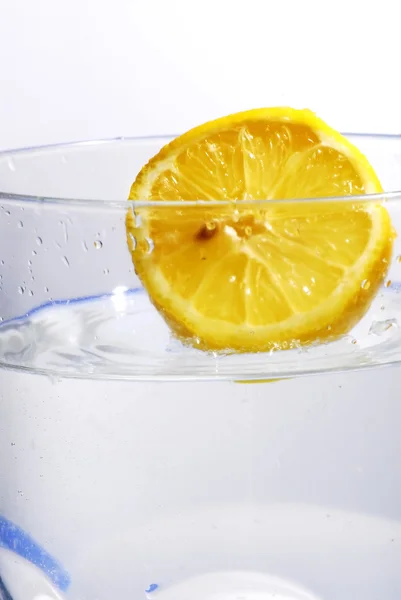 Limón cayendo en el agua clara — Foto de Stock