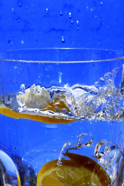 Limón cayendo en el agua clara — Foto de Stock