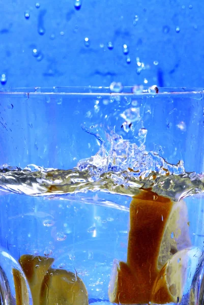 Limón cayendo en el agua clara — Foto de Stock