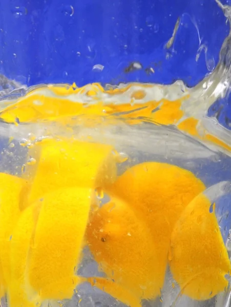 Лимон падает в чистую воду — стоковое фото