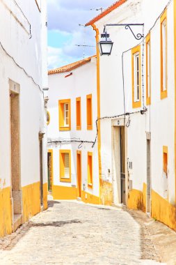 Old urban street and white facades in Evora. Alentejo, Portugal clipart