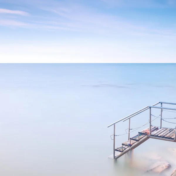 海の水に木製のはしご桟橋。長時間露光. — ストック写真