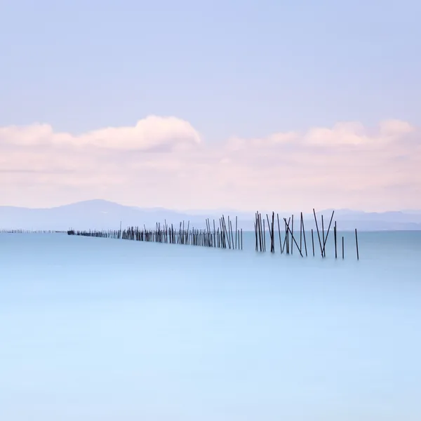 Bastoncini da pesca e acqua dolce sul paesaggio marino. Lunga esposizione . — Foto Stock