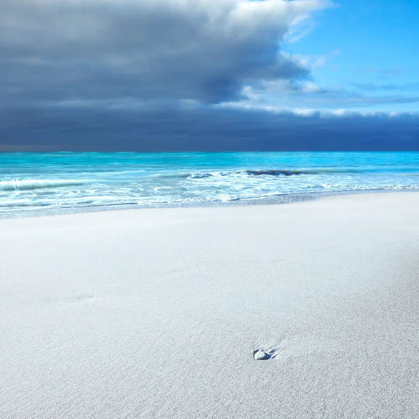 Roca blanca en una playa blanca bajo un cielo azul nublado — Foto de Stock