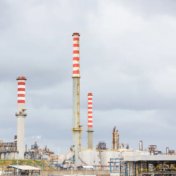 Indústria de refinaria de petróleo, pilhas de fumaça no fundo do céu nublado — Fotografia de Stock