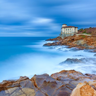 Boccale castle landmark on cliff rock and sea. Tuscany, Italy. Long exposure photography. clipart