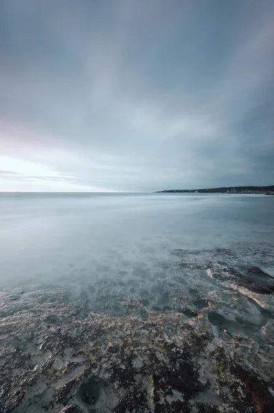 Batık kaya, okyanus ve bulutlu gökyüzü bay Beach — Stok fotoğraf