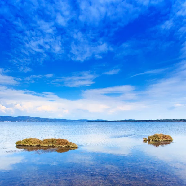 Dos pequeñas islas verdes en un lago azul bajo el cielo despejado. Argentario, Toscana, Italia . —  Fotos de Stock