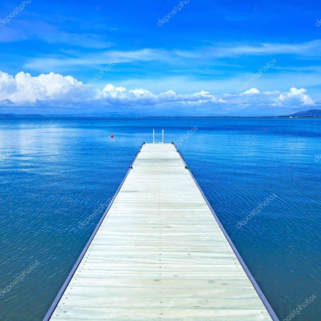 Wooden pier or jetty on a blue ocean. Beach in Argentario, Tuscany, Italy