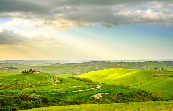 Tuscany, rural sunset landscape. Countryside farm, white road and cypress trees.